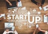 how to start a business - top down view of people at laptops with text on the table